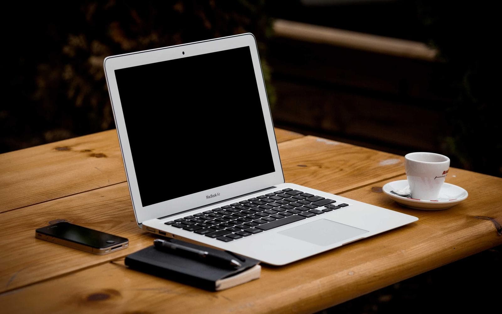 Laptop and a cup of coffee on a wooden table